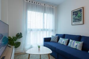 - un canapé bleu dans le salon avec une table dans l'établissement Eli Canteras-Parking-Airco by CanariasGetaway, à Las Palmas de Gran Canaria