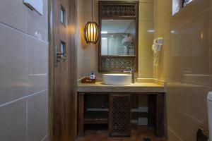 La salle de bains est pourvue d'un lavabo et d'un miroir. dans l'établissement Lijiang Gui Yuan Tian Ju Guesthouse, à Lijiang