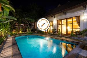 a swimming pool in front of a building at night at Dura Villas Canggu Bali in Kerobokan