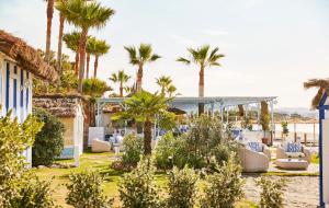 a resort with palm trees and chairs on the beach at Marbella Club Hotel · Golf Resort & Spa in Marbella