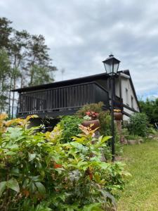 ein Haus mit Straßenbeleuchtung und einigen Pflanzen in der Unterkunft Biały Domek nad Wkrą in Popielżyn Górny