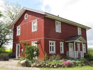 a red house with flowers in front of it at Hof Osterbunsbüll in Mittelangeln