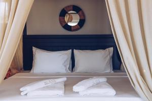 a bed with two pillows and a mirror on the wall at Hill House Adult Only in Kaş