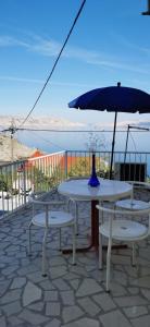 einen Tisch und zwei Stühle und einen Regenschirm auf einer Terrasse in der Unterkunft Apartment Varga in Sveti Juraj