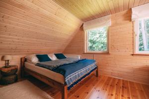 a bedroom with a bed in a log cabin at Łap Las Pelnik in Pelnik