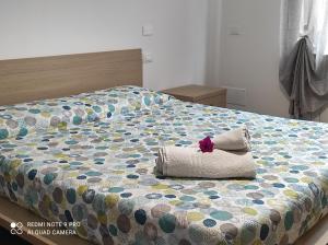 Una cama con un edredón con una flor. en Marone Villa con Giardino Vista Lago Private Parking, en Marone