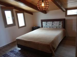 una camera con un grande letto e due finestre di Loft by the sea-Agios Nikolaos-Lefkada ad Ágios Nikólaos
