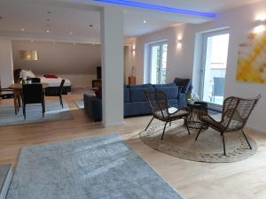 a living room with chairs and a blue couch at Loft "Island" in Leutkirch im Allgäu