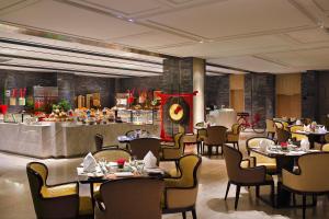 un restaurante con mesas y sillas y un buffet en Crowne Plaza Beijing Lido, an IHG Hotel, en Beijing