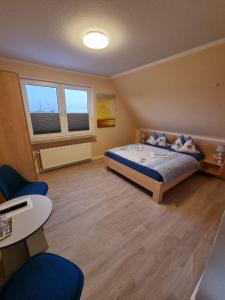 a bedroom with a bed and two windows at Hotel Pension Nordseewelle in Norddeich