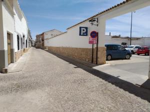 una calle vacía al lado de un edificio con un estacionamiento en Apartaloft LA CELESTINA, en Almagro