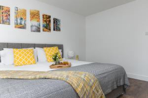 a bedroom with a bed and paintings on the wall at KVM - City Apartments in Peterborough