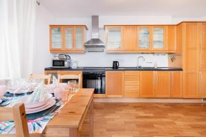 una cocina con armarios de madera y una mesa con gafas. en Apartments Tarifa - by the sea by Renters en Sopot