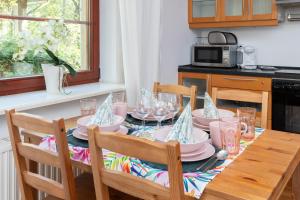 una mesa de comedor con sillas y una mesa con platos y vasos. en Apartments Tarifa - by the sea by Renters en Sopot