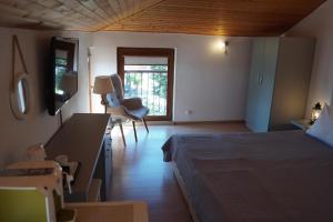 a bedroom with a bed and a desk and a window at Guest House Lambovi in Nesebar