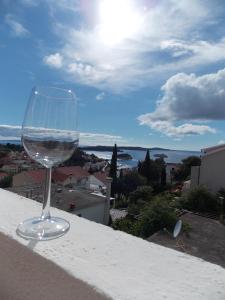 a glass of wine sitting on a ledge at Apartments and Rooms Jasna in Hvar