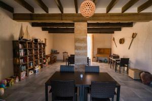 Una habitación con una mesa, sillas y estanterías. en Agroturismo Sa Canoveta, en Colonia de Sant Jordi
