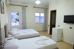 Habitación con 2 camas y TV de pantalla plana. en Hotel Rixhi, en Sarandë