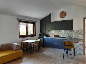 cocina con armarios azules, mesa y sillas en Appartamento SG, en Sistiana