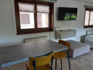 un soggiorno con tavolo, sedie e letto di Appartamento SG a Sistiana