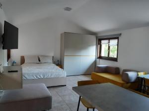 a bedroom with a bed and a couch and a table at Appartamento SG in Sistiana