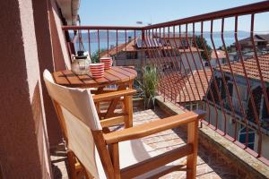 a balcony with a table and chairs and the ocean at Guest House Lambovi in Nesebar