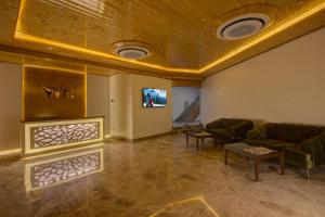 a living room with a couch and a tv at Woodrock Luxury Boutique Hotel in Manāli