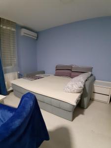 um quarto com uma cama e uma parede azul em MIMOZA 1 em Jagodina