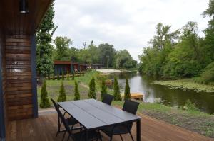 stół i krzesła na tarasie nad rzeką w obiekcie Fisherman w Kijowie