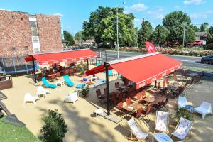 widok na restaurację z krzesłami i parasolami w obiekcie Élmény Balaton Hotel w Alsóörs