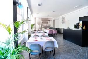 rzędu stołów w pokoju z roślinami w obiekcie Élmény Balaton Hotel w Alsóörs