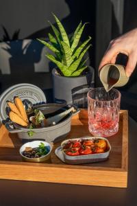 a person pouring a drink into a tray of food at INNSiDE by Meliá Luxembourg in Luxembourg