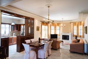 a living room with a table and chairs and a kitchen at Luxury Rustic Villa Mountain View in Lefkada Town