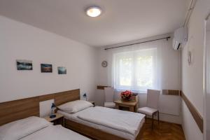 two beds in a room with a window at Kis János Apartman in Sopron