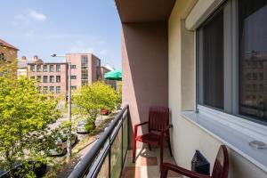 a balcony with two chairs and a window at Kis János Apartman in Sopron