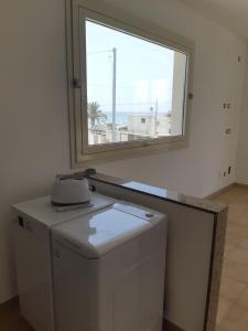 lavadora en una habitación con ventana en Fronte Mare, en Avola