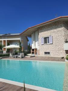 a swimming pool in front of a house at Appartamenti Villa Gloria in Peschiera del Garda