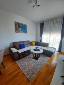 ein Wohnzimmer mit einem Sofa und einem Tisch in der Unterkunft Lux Apartment Talija in Budva
