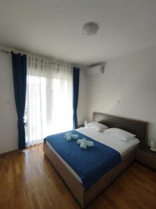 ein Schlafzimmer mit einem großen Bett mit zwei Handtüchern darauf in der Unterkunft Lux Apartment Talija in Budva