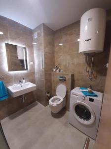 ein Badezimmer mit einem WC und einer Waschmaschine in der Unterkunft Lux Apartment Talija in Budva