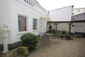 a patio area with chairs, tables, and umbrellas at Pension Ikar in Schwerin