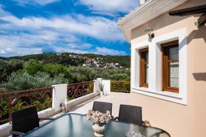 a patio with a table and chairs on a balcony at Luxury Rustic Villa Mountain View in Lefkada Town