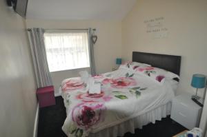 een slaapkamer met een bed met roze bloemen erop bij Devon Guest House in Blackpool