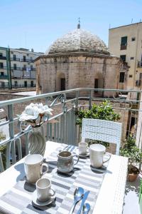 a table with cups and saucers on a balcony at Il Pendio B&B in Bisceglie