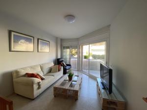 sala de estar con sofá y TV en R123 Apartamento en la planta baja con piscina cerca de la playa en Calafell