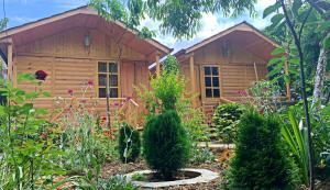 a log cabin with a garden in front of it at Old City Hotel in Kutaisi