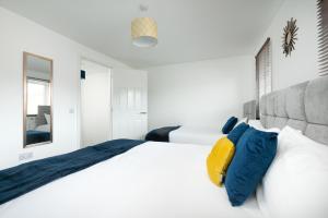 a bedroom with a large white bed with blue pillows at KVM - Thorpe House in Peterborough