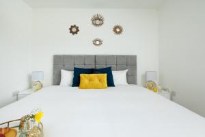 a bedroom with a large bed with blue and yellow pillows at KVM - Thorpe House in Peterborough