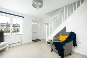a living room with a chair with a yellow pillow at KVM - Thorpe House in Peterborough