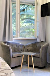 a couch sitting in a living room with a window at Sea Garden Rooms in Termoli